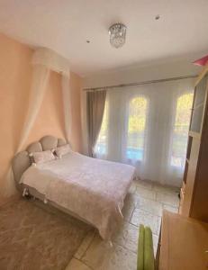 sypialnia z dużym łóżkiem i oknami w obiekcie Villa du Soleil en Provence sur le Domaine du Golf de Pont Royal w mieście Mallemort +21 zdjęć