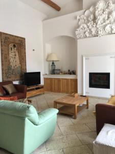 a living room with a couch and a fireplace at Villa du Soleil en Provence sur le Domaine du Golf de Pont Royal in Mallemort