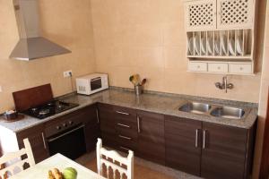 a small kitchen with a sink and a microwave at Casa La Maceta in Cádiz