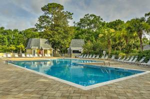 a swimming pool with chairs and a house at Hilton Head Island Villa On Golf Course! in Hilton Head Island