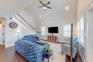 a living room with a blue couch and chairs at Beachy Dunes OBX KDH128 in Kill Devil Hills