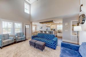 a bedroom with a bed and a living room at Beachy Dunes OBX KDH128 in Kill Devil Hills