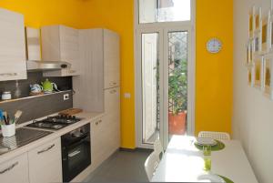 a kitchen with yellow walls and a stove and a window at Welcome Friends in Rome