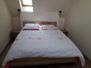 ein Schlafzimmer mit einem Bett mit einer weißen Bettdecke in der Unterkunft Lodge avec SPA pour 6 pers, proche de Guédelon in Tannerre-en-Puisaye
