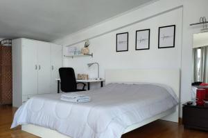 een witte slaapkamer met een bed en een bureau bij Acropolis 360 in Athene