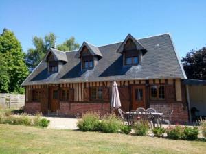 a large wooden house with a table and chairs at La bergerie, cottage normand 5 pers. avec piano in Épreville-en-Lieuvin