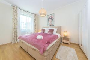 sypialnia z dużym łóżkiem i dużym oknem w obiekcie Pomorskie Apartamenty Bernadowska Green Deluxe w mieście Gdynia