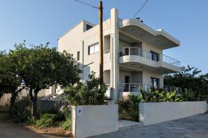 a white house with a balcony on a street at Fotini 's apartment near the city center. in Chania