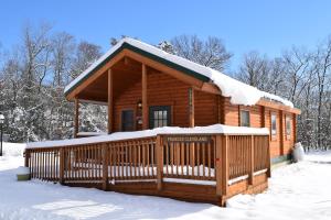 a log cabin with snow on the roof at Cherry Hill Park in College Park