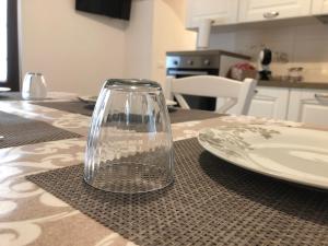 un vaso di vetro seduto su un tavolo accanto a un piatto di Le Stelle di Nonna Anna a Monopoli