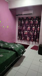 a bedroom with a green bed and a purple wall at Homestay D'chacha in Petaling Jaya
