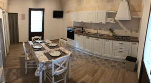 een keuken met witte kasten en een tafel met stoelen bij Le Stelle di Nonna Anna in Monopoli