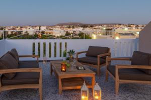 a patio with chairs and a table on a balcony at H Experience Spectacular Rooftop Loft in Heraklio