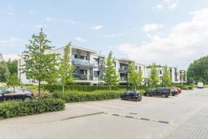 parking z samochodami zaparkowanymi przed budynkiem w obiekcie Pomorskie Apartamenty Bernadowska Green Deluxe w mieście Gdynia
