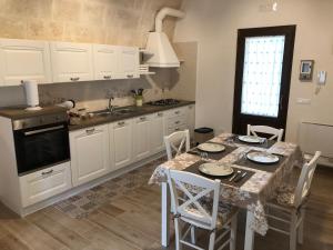a kitchen with a table with chairs and a sink at Le Stelle di Nonna Anna in Monopoli