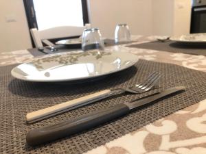 een tafel met een bord en een vork en mes bij Le Stelle di Nonna Anna in Monopoli