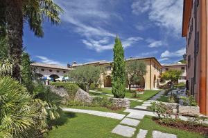 a garden with a tree and a building at Residence La Filanda in Costermano