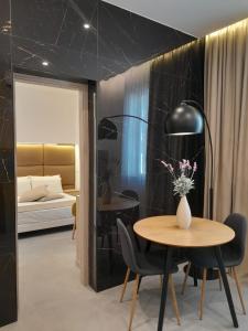 um quarto com uma mesa e cadeiras e uma cama em BAARIA House Hotel em Barcellona Pozzo di Gotto