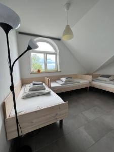 Cette chambre comprend deux lits, une lampe et une fenêtre. dans l'établissement Jurgis Guest house, à Kaunas