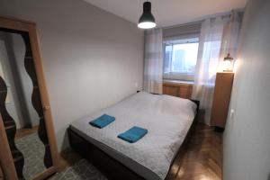 a small bedroom with a bed with two blue pillows on it at Hey Apartments in Warsaw
