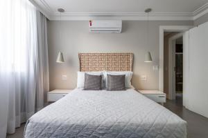 una camera bianca con un grande letto con cuscini di Moderno em Ipanema - Ótimo para famílias - RE406 Z2 a Rio de Janeiro