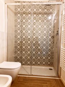 a bathroom with a shower with a toilet and a sink at Gatto Bianco Bergamo Apartment in Bergamo