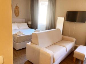 Gatto Bianco Bergamo Apartment في بيرغامو: غرفه فندقيه بسرير واريكه