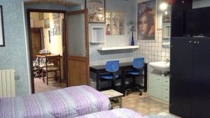 a bedroom with a kitchen with a table and blue stools at Affittacamere Il Giramondo in Foligno
