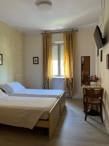 una camera con letto, tavolo e scrivania di Albergo AQUILA a Lazise