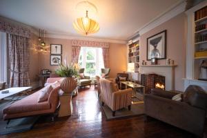 a living room filled with furniture and a fireplace at Eleven Didsbury Park Hotel in Manchester