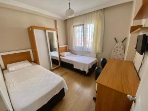 Habitación pequeña con 2 camas y espejo. en Mazlum Apart, en Trabzon