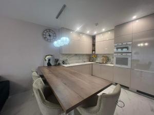 een keuken met een houten tafel en een aantal stoelen bij Beverly Hills House pri potoku by Pinkreal in Solčany