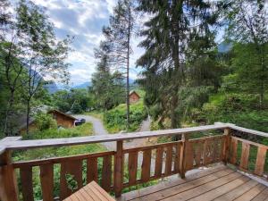 una terraza de madera con vistas a un bosque en Les cabanes du domaine de l Esperluette en Le Lauzet-Ubaye