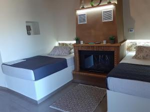 Zimmer mit 2 Betten und einem Kamin in der Unterkunft Panagiotas House in Monemvasia