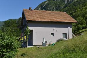 une maison blanche avec un toit marron sur une colline dans l'établissement Kuca za odmor Dragina, à Perućac