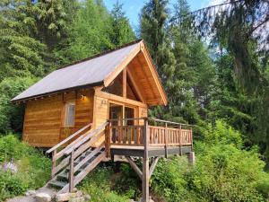 une cabine dans les bois avec une grande terrasse dans l'établissement Les cabanes du domaine de l Esperluette, au Lauzet-Ubaye