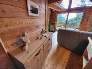 um quarto com painéis de madeira e um banco numa pequena casa em Les cabanes du domaine de l Esperluette em Le Lauzet-Ubaye