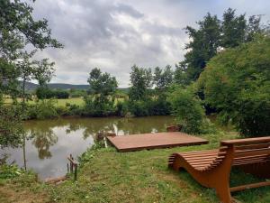 a bench sitting next to a pond with a table at Ferienwohnung Lebensbaum in Trimberg in Elfershausen