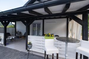 a patio with a table and chairs under a pergola at Vikendica Lohovo in Bihać