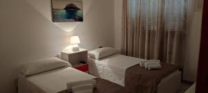 a small room with two beds and a lamp at Villa da Rosa in Olbia +27 photos
