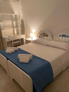 a bedroom with a large bed with towels on it at Villa da Rosa in Olbia