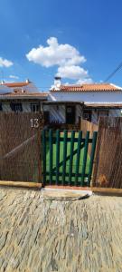 a pair of green chairs sitting in front of a fence at Sunrise Monsaraz Green - 1km Castelo Monsaraz com telheiro e jardim in Monsaraz