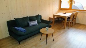 a living room with a green couch and a table at WaldBlick im Happy Allgäu - Wohnung mit großer Dachterrasse in Leutkirch im Allgäu