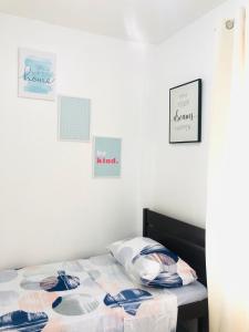P&Y 114 House for rent في Bayugan City: غرفة نوم بسرير وصور على الحائط