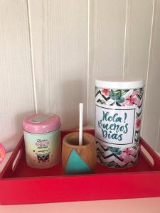 a red tray with two containers and a candle at Casa Roja in El Calafate +1 photo