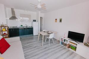 uma sala de estar branca com uma mesa e uma cozinha em Alma 28 em Los Cancajos
