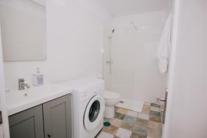 baño blanco con lavadora y aseo en Alma 28, en Los Cancajos