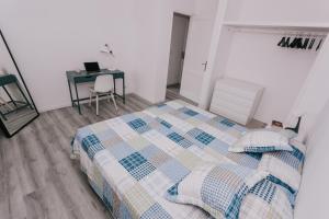 Un dormitorio con una cama y un escritorio con una computadora portátil. en Alma 28, en Los Cancajos 16 fotos más