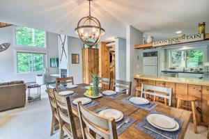 a kitchen and dining room with a wooden table and chairs at Cozy Lincoln Condo about 1 Mi to Loon Mountain! in Lincoln