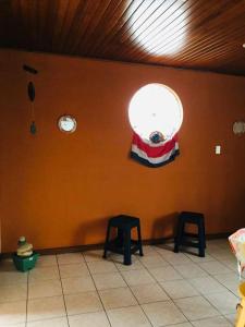 a room with two stools and a wall with a flag at Casa Bambú Tropical in Alajuela